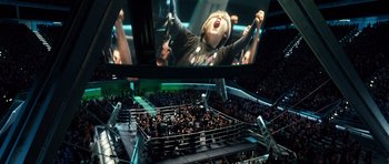 Movie still from “Real Steel” (2011), directed by Shawn Levy – A crowd of people in a boxing ring watching an event on tv; Wide shot, High angle