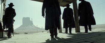 Movie still from “The Lone Ranger” (2013), directed by Gore Verbinski – Two men are standing on a porch looking out at the sky; Wide shot, Low angle