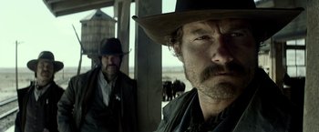 Movie still from “The Lone Ranger” (2013), directed by Gore Verbinski – A man in a cowboy hat is looking at the camera while another man in a cowboy hat looks at the camera; Close Up shot, Low angle