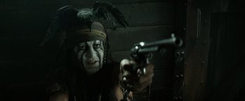 Movie still from “The Lone Ranger” (2013), directed by Gore Verbinski – A man with a crow on his head holding a gun in his hand; Close Up shot, Over the shoulder angle