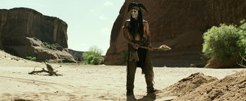 Movie still from “The Lone Ranger” (2013), directed by Gore Verbinski – A man with a long black beard holding a spear; Wide shot, Low angle