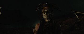 Movie still from “The Lone Ranger” (2013), directed by Gore Verbinski – A man in a native american costume is standing in the dark; Close Up shot, Low angle