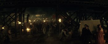 Movie still from “The Lone Ranger” (2013), directed by Gore Verbinski – A group of people walking through a street at night; Extreme Wide shot, High angle