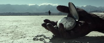Movie still from “The Lone Ranger” (2013), directed by Gore Verbinski – A hand holding a pocket watch on the ground; Extreme Close Up shot, Low angle