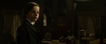 Movie still from “The Lone Ranger” (2013), directed by Gore Verbinski – A boy in a suit and tie standing in front of an old clock; Close Up shot, Low angle