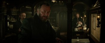 Movie still from “The Lone Ranger” (2013), directed by Gore Verbinski – An old man with a beard is standing in a dark room; Close Up shot, Low angle