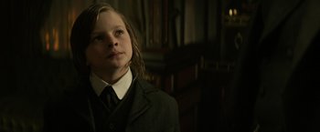 Movie still from “The Lone Ranger” (2013), directed by Gore Verbinski – A young boy in a suit and tie looking to his left; Close Up shot, Low angle