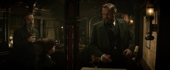 Movie still from “The Lone Ranger” (2013), directed by Gore Verbinski – A man standing at a table in a room with a woman; Medium shot, Over the shoulder angle