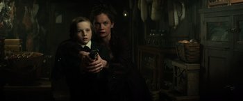 Movie still from “The Lone Ranger” (2013), directed by Gore Verbinski – A woman and a child holding a gun; Medium shot, Low angle