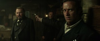 Movie still from “The Lone Ranger” (2013), directed by Gore Verbinski – A man holding a gun pointed at the camera; Close Up shot, Over the shoulder angle