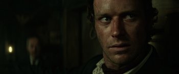 Movie still from “The Lone Ranger” (2013), directed by Gore Verbinski – A man's face in a dark room; Close Up shot, Over the shoulder angle