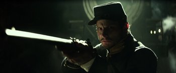 Movie still from “The Lone Ranger” (2013), directed by Gore Verbinski – A man holding a rifle in a dark room; Close Up shot, Low angle
