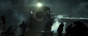 Movie still from “The Lone Ranger” (2013), directed by Gore Verbinski – A man standing next to a train on a train track; Wide shot, Low angle
