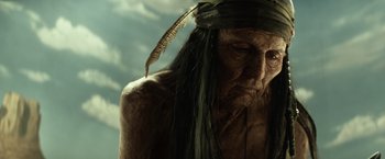 Movie still from “The Lone Ranger” (2013), directed by Gore Verbinski – An old man with a long black feather in his hair; Close Up shot, Low angle