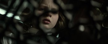 Movie still from “The Lone Ranger” (2013), directed by Gore Verbinski – A young girl looking through a chain link fence; Close Up shot, Low angle