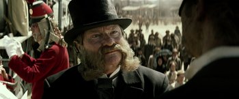 Movie still from “The Lone Ranger” (2013), directed by Gore Verbinski – An old man with a long beard wearing a top hat; Close Up shot, Over the shoulder angle