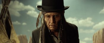 Movie still from “The Lone Ranger” (2013), directed by Gore Verbinski – An old man wearing a top hat and feathers; Close Up shot, Low angle