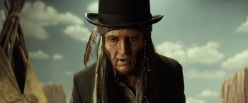 Movie still from “The Lone Ranger” (2013), directed by Gore Verbinski – An old man wearing a top hat with feathers on it; Close Up shot, Low angle