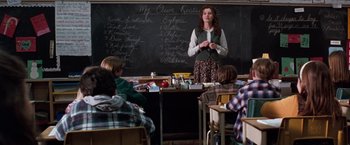 Movie still from “The Long Kiss Goodnight” (1996), directed by Renny Harlin – A woman standing in front of a chalkboard; Medium shot, High angle