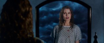 Movie still from “The Long Kiss Goodnight” (1996), directed by Renny Harlin – A woman in a polka dot dress standing in front of a mirror; Medium shot, Over the shoulder angle