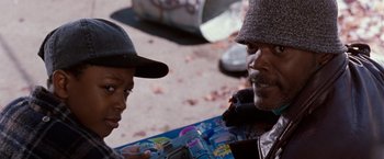 Movie still from “The Long Kiss Goodnight” (1996), directed by Renny Harlin – Two young men talking to each other on the sidewalk; Close Up shot, Over the shoulder angle