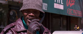 Movie still from “The Long Kiss Goodnight” (1996), directed by Renny Harlin – A man wearing a hat talking on a cell phone; Close Up shot, Low angle