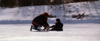 Movie still from “The Long Kiss Goodnight” (1996), directed by Renny Harlin – Two people sitting in the snow on the ground; Wide shot, High angle