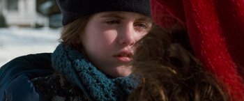 Movie still from “The Long Kiss Goodnight” (1996), directed by Renny Harlin – A person wearing a hat and holding an umbrella; Close Up shot, Over the shoulder angle