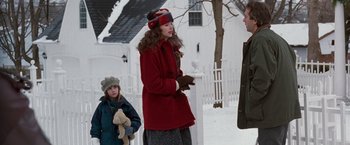 Movie still from “The Long Kiss Goodnight” (1996), directed by Renny Harlin – A woman in a red coat talking to a man in a red coat; Medium shot, Over the shoulder angle