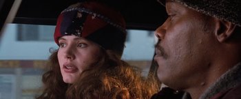 Movie still from “The Long Kiss Goodnight” (1996), directed by Renny Harlin – A man and a woman sitting in a car looking at each other; Close Up shot, Over the shoulder angle