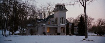 Movie still from “The Long Kiss Goodnight” (1996), directed by Renny Harlin – A large white house sitting on top of a snow covered field; Extreme Wide shot, Low angle