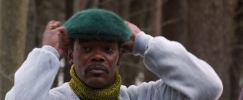 Movie still from “The Long Kiss Goodnight” (1996), directed by Renny Harlin – A man with a green hat and a yellow neck scarf; Close Up shot, Low angle
