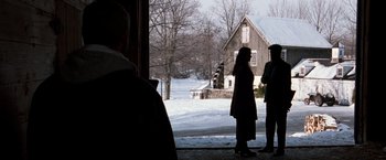 Movie still from “The Long Kiss Goodnight” (1996), directed by Renny Harlin – Two people standing in front of an old barn; Wide shot, Over the shoulder angle