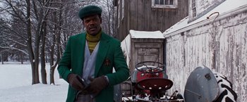 Movie still from “The Long Kiss Goodnight” (1996), directed by Renny Harlin – A man wearing a green jacket and a green hat; Medium shot, Low angle