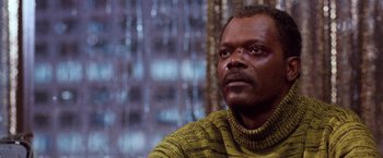 Movie still from “The Long Kiss Goodnight” (1996), directed by Renny Harlin – A man wearing a sweater looking to his left; Close Up shot, Low angle