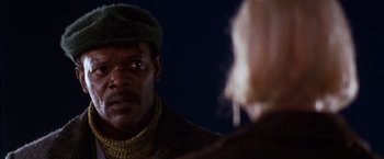 Movie still from “The Long Kiss Goodnight” (1996), directed by Renny Harlin – A person wearing a hat and looking at another person; Close Up shot, Over the shoulder angle