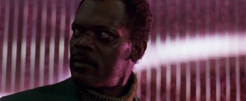 Movie still from “The Long Kiss Goodnight” (1996), directed by Renny Harlin – A man's face in front of a purple background; Close Up shot, Low angle