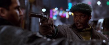 Movie still from “The Long Kiss Goodnight” (1996), directed by Renny Harlin – A man holding a gun pointed at the camera; Close Up shot, Low angle