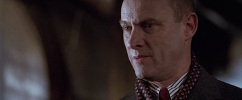Movie still from “The Long Kiss Goodnight” (1996), directed by Renny Harlin – A person wearing a suit and tie; Close Up shot, Low angle