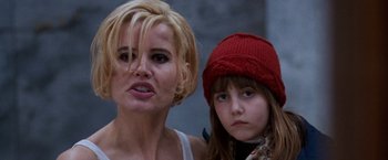 Movie still from “The Long Kiss Goodnight” (1996), directed by Renny Harlin – A woman and a girl are standing next to each other; Close Up shot, Low angle