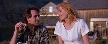 Movie still from “The Long Kiss Goodnight” (1996), directed by Renny Harlin – A man and a woman sitting next to each other; Medium shot, Low angle