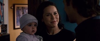 Movie still from “The Lookout” (2007), directed by Scott Frank – A woman holding a baby in her arms and smiling; Close Up shot, Over the shoulder angle