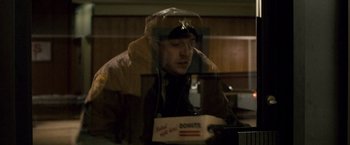 Movie still from “The Lookout” (2007), directed by Scott Frank – A man sitting in front of a box of donuts; Medium shot, High angle