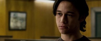 Movie still from “The Lookout” (2007), directed by Scott Frank – A young man with long black hair stares into the camera; Close Up shot, Low angle