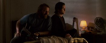 Movie still from “The Lookout” (2007), directed by Scott Frank – Two men sitting on a couch in the dark; Medium shot, Low angle