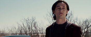 Movie still from “The Lookout” (2007), directed by Scott Frank – A man standing in front of some trees and a car; Close Up shot, Low angle
