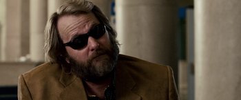 Movie still from “The Lookout” (2007), directed by Scott Frank – A person wearing a suit and sunglasses; Close Up shot, Over the shoulder angle