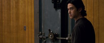 Movie still from “The Lookout” (2007), directed by Scott Frank – A man standing in front of an open door; Close Up shot, Over the shoulder angle