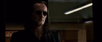 Movie still from “The Lookout” (2007), directed by Scott Frank – A man with long black hair wearing sunglasses; Close Up shot, Low angle