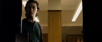 Movie still from “The Lookout” (2007), directed by Scott Frank – A young man standing in a room with his hands in his pockets; Medium shot, Low angle